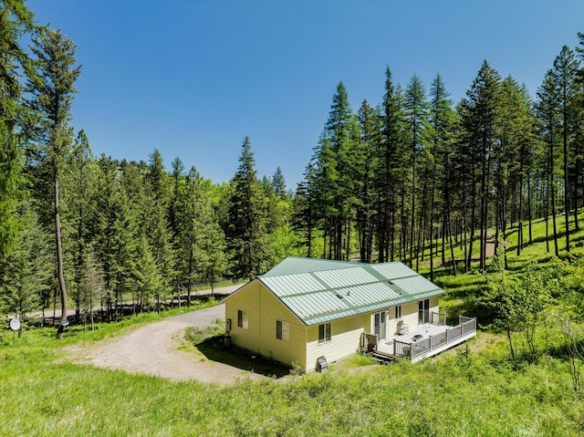 42843 Jette Lake Trl, Polson, MT 59860 - view of home's exterior with a wooden deck, a wooded view, metal roof, and a standing seam roof