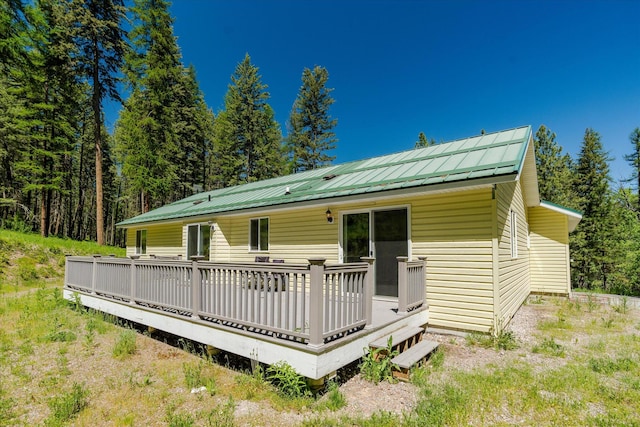 42843 Jette Lake Trl, Polson, MT 59860 - back of property featuring metal roof, roof mounted solar panels, and a wooden deck