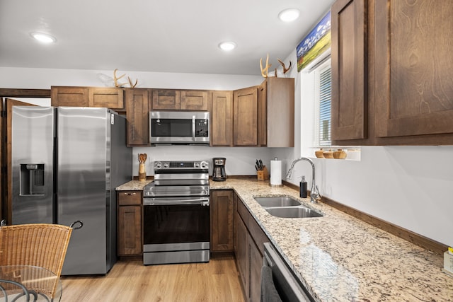 108 Timmons St, Dillon, MT 59725 - kitchen with appliances with stainless steel finishes, a sink, light stone counters, light wood-type flooring, and recessed lighting