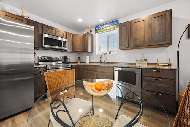 108 Timmons St, Dillon, MT 59725 - kitchen with stainless steel appliances, light wood-style floors, a sink, dark brown cabinetry, and recessed lighting