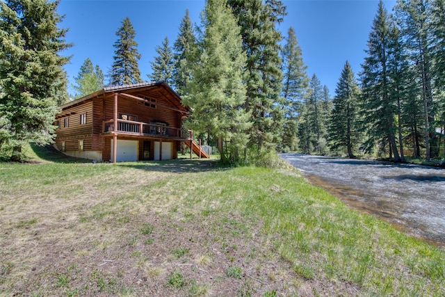 1795 E Fork Rd, Sula, MT 59871 - back of house with log siding, stairs, a deck, an attached garage, and driveway