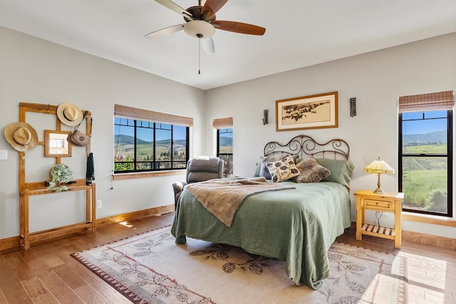 144 Prickly Pear Ct, Florence, MT 59833 - bedroom featuring multiple windows, wood finished floors, and ceiling fan