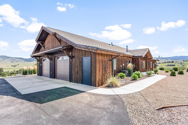144 Prickly Pear Ct, Florence, MT 59833 - view of side of home featuring a mountain view, board and batten siding, and concrete driveway