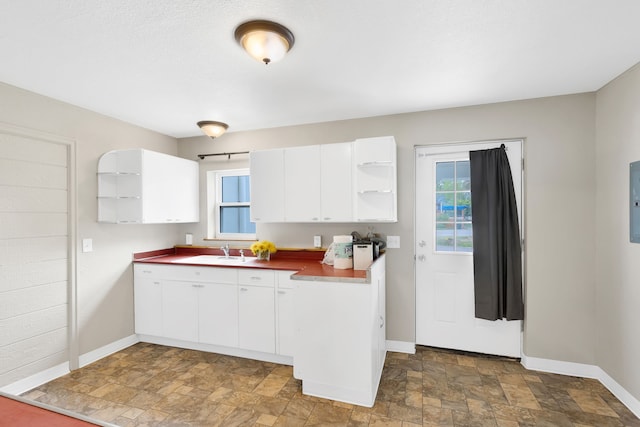 245 Marcus St, Hamilton, MT 59840 - kitchen with stone finish floors, open shelves, white cabinets, dark countertops, and electric panel
