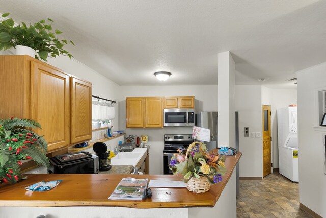 245 Marcus St, Hamilton, MT 59840 - kitchen featuring appliances with stainless steel finishes, estacked washer and dryer, and stone finish flooring