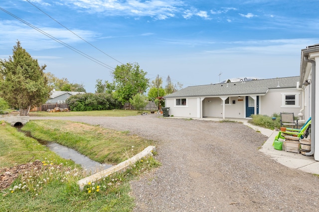 245 Marcus St, Hamilton, MT 59840 - view of front of house featuring driveway, stucco siding, and a shingled roof