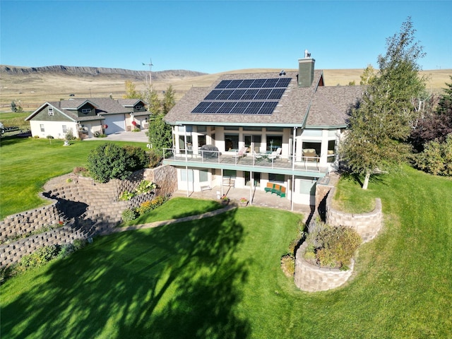 50-60 Willow Bend Ln, Cascade, MT 59421 - back of property with roof mounted solar panels, a patio area, a yard, a chimney, and stucco siding