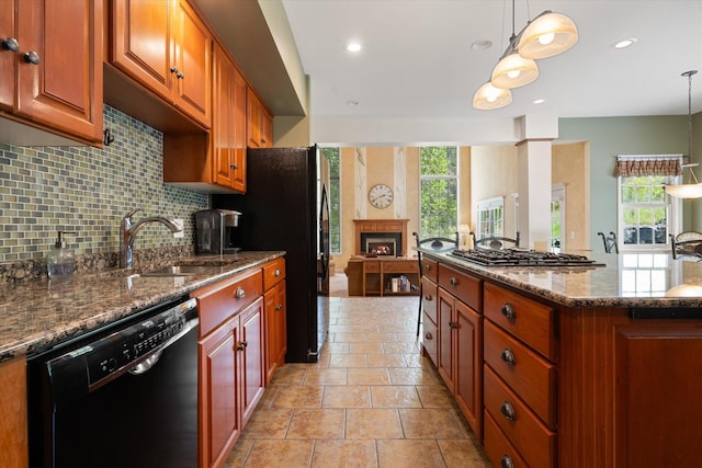 1 Reeders Village Dr, Helena, MT 59601 - kitchen featuring black appliances, a sink, tasteful backsplash, a lit fireplace, and dark stone countertops