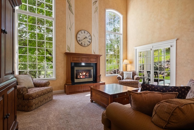 1 Reeders Village Dr, Helena, MT 59601 - carpeted living room featuring healthy amount of natural light, a glass covered fireplace, and a high ceiling