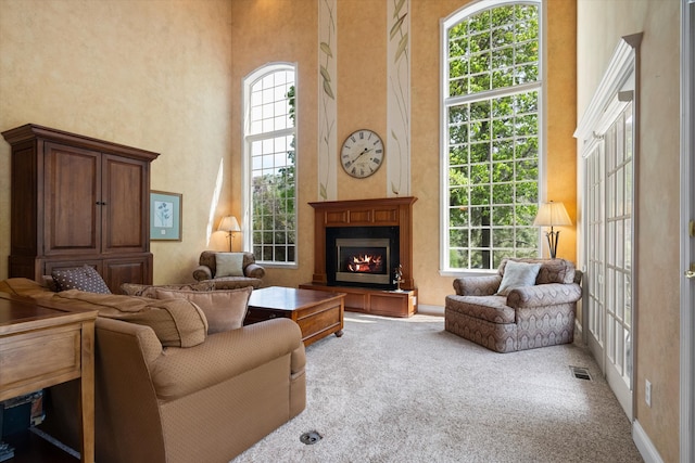 1 Reeders Village Dr, Helena, MT 59601 - living room featuring a towering ceiling, carpet, and a warm lit fireplace