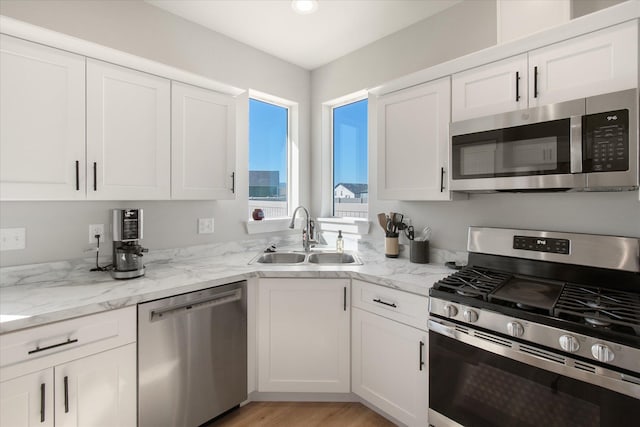259 Meadow View Loop, East Helena, MT 59635 - kitchen with stainless steel appliances, a sink, white cabinetry, and light wood-style floors