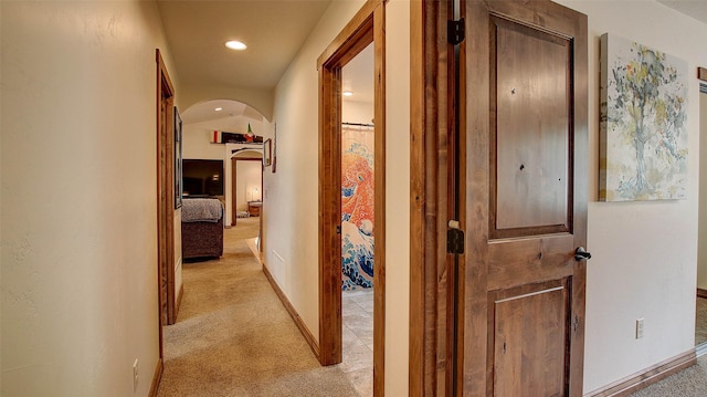 122 Bernie Rd, Alberton, MT 59820 - hallway featuring arched walkways, light carpet, baseboards, and recessed lighting
