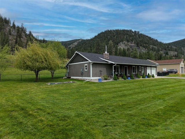 122 Bernie Rd, Alberton, MT 59820 - back of property with a mountain view, a garage, a chimney, driveway, and a porch