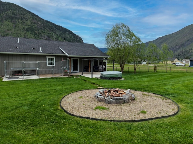 122 Bernie Rd, Alberton, MT 59820 - rear view of house with a hot tub, a patio area, a fire pit, and a mountain view
