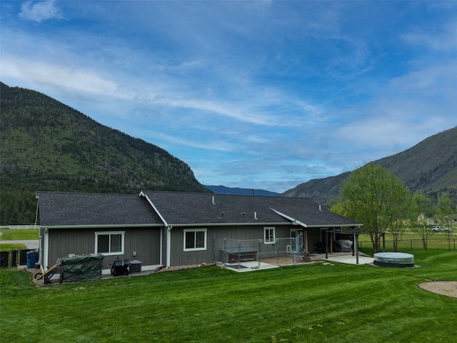 122 Bernie Rd, Alberton, MT 59820 - back of property featuring a hot tub, a mountain view, and a patio area