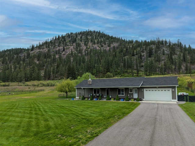 122 Bernie Rd, Alberton, MT 59820 - view of front facade with an attached garage, a front lawn, and a view of trees