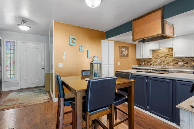 1861 E Broadway St, Missoula, MT 59802 - kitchen with blue cabinets, decorative backsplash, light countertops, wood finished floors, and white cabinets