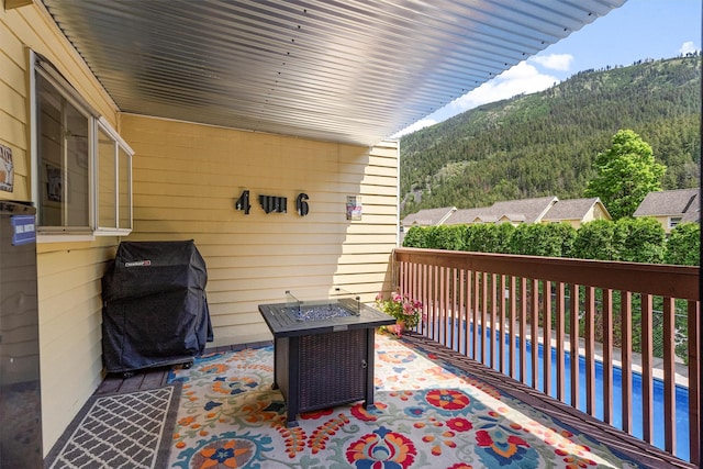 1861 E Broadway St, Missoula, MT 59802 - view of patio / terrace with a mountain view, a grill, a pool, a fire pit, and a view of trees