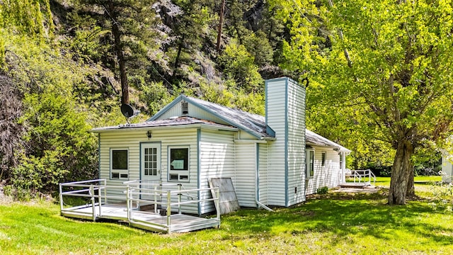 1160 US Highway 12 E, Townsend, MT 59644 - back of property with a deck, a chimney, and a lawn