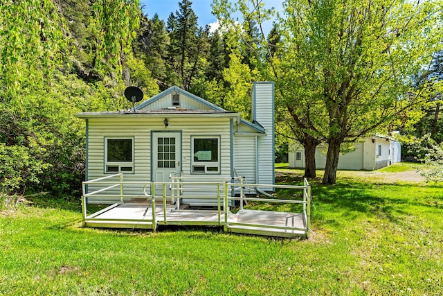 1160 US Highway 12 E, Townsend, MT 59644 - rear view of house with a yard, a wooden deck, and a chimney
