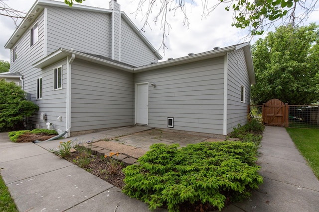 3401 Ravalli St, Bozeman, MT 59718 - rear view of house with a gate, a patio area, and a chimney