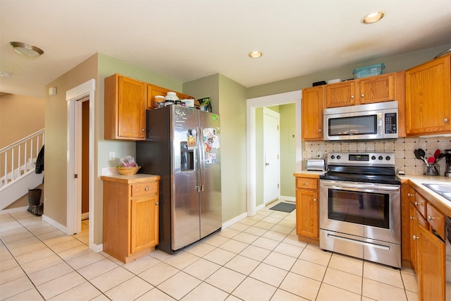 3401 Ravalli St, Bozeman, MT 59718 - kitchen with appliances with stainless steel finishes, light countertops, backsplash, light tile patterned floors, and recessed lighting