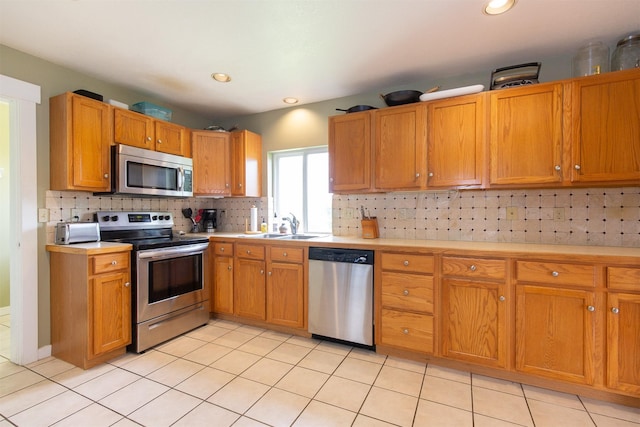 3401 Ravalli St, Bozeman, MT 59718 - kitchen with stainless steel appliances, light countertops, a sink, backsplash, and light tile patterned floors