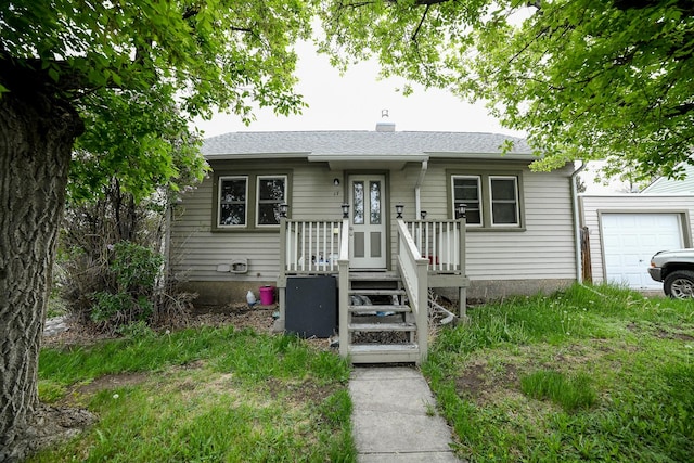 17 9th St NW, Great Falls, MT 59404 - view of front facade with an attached garage, a chimney, and roof with shingles