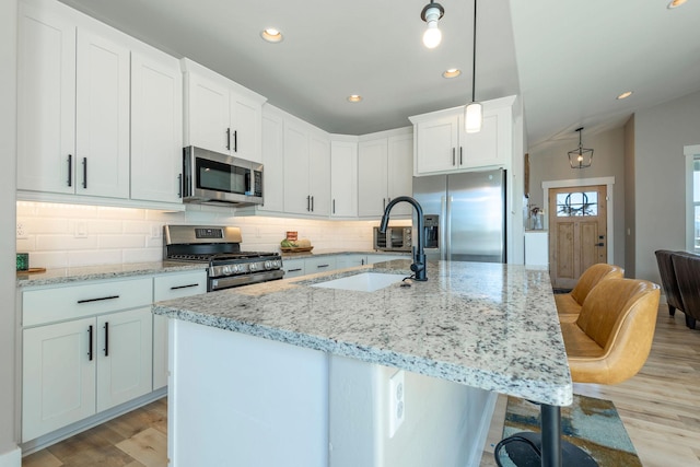 2805 Travis Ave, Helena, MT 59601 - kitchen with appliances with stainless steel finishes, a sink, light wood finished floors, recessed lighting, and tasteful backsplash