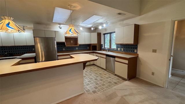 10 Pine Ridge Cir, Clancy, MT 59634 - kitchen with appliances with stainless steel finishes, a sink, decorative light fixtures, decorative backsplash, and white cabinets
