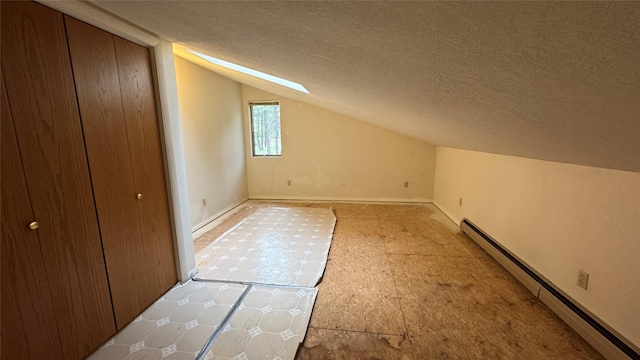 10 Pine Ridge Cir, Clancy, MT 59634 - additional living space with a baseboard radiator, vaulted ceiling, a textured ceiling, and a skylight