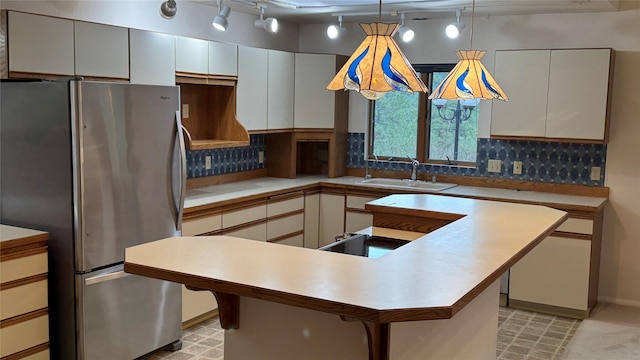 10 Pine Ridge Cir, Clancy, MT 59634 - kitchen with freestanding refrigerator, track lighting, a sink, and decorative backsplash