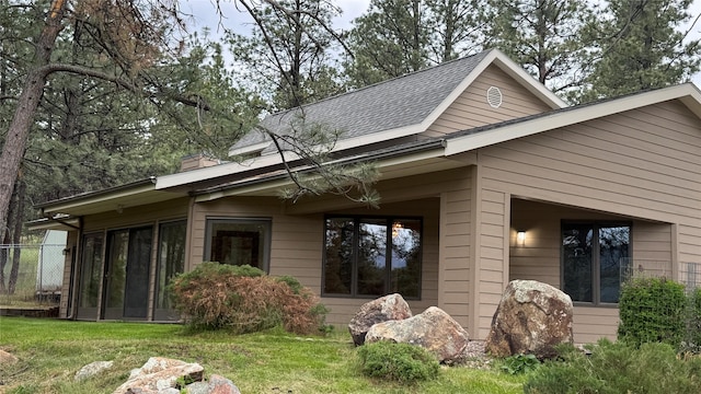 10 Pine Ridge Cir, Clancy, MT 59634 - view of side of home featuring roof with shingles, a chimney, and a sunroom