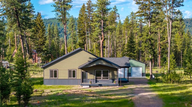 165 Lynx Ct, Seeley Lake, MT 59868 - view of front facade with a wooded view, a detached garage, and driveway