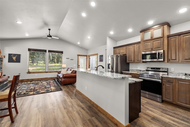 165 Lynx Ct, Seeley Lake, MT 59868 - kitchen with stainless steel appliances, wood finished floors, lofted ceiling, open floor plan, and ceiling fan