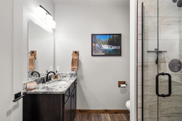 165 Lynx Ct, Seeley Lake, MT 59868 - bathroom with wood finished floors, vanity, a stall shower, and toilet