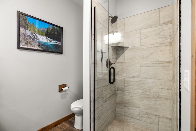 165 Lynx Ct, Seeley Lake, MT 59868 - bathroom with a stall shower, toilet, wood finished floors, and baseboards