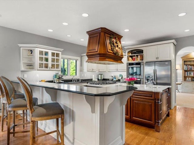140 Fairway Dr, Missoula, MT 59803 - kitchen with stainless steel appliances, a breakfast bar, recessed lighting, open shelves, and light wood-style flooring