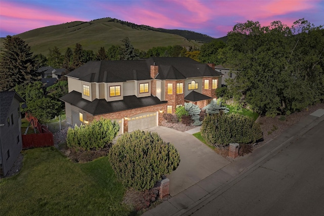 140 Fairway Dr, Missoula, MT 59803 - view of front facade with a garage, concrete driveway, a chimney, and a mountain view