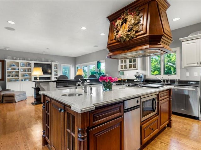 140 Fairway Dr, Missoula, MT 59803 - kitchen with stainless steel appliances, open floor plan, a center island with sink, light stone countertops, and light wood-type flooring