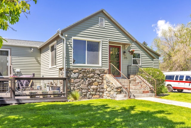 215 N Oak St, Townsend, MT 59644 - view of front of home featuring a front lawn, a deck, and stone siding