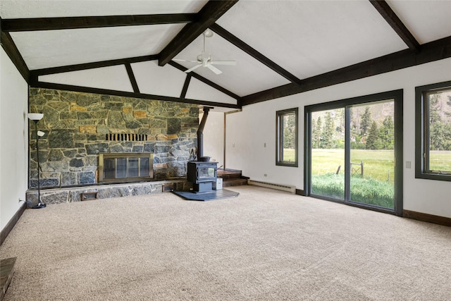 1165 Rock Creek Rd, Clinton, MT 59825 - unfurnished living room featuring carpet flooring, a wood stove, a baseboard heating unit, and a ceiling fan
