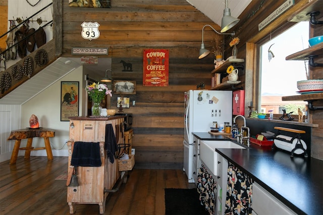 49 Redtail Hawk Rd, Mcallister, MT 59740 - kitchen featuring lofted ceiling, dark wood-style flooring, dark countertops, log walls, and freestanding refrigerator