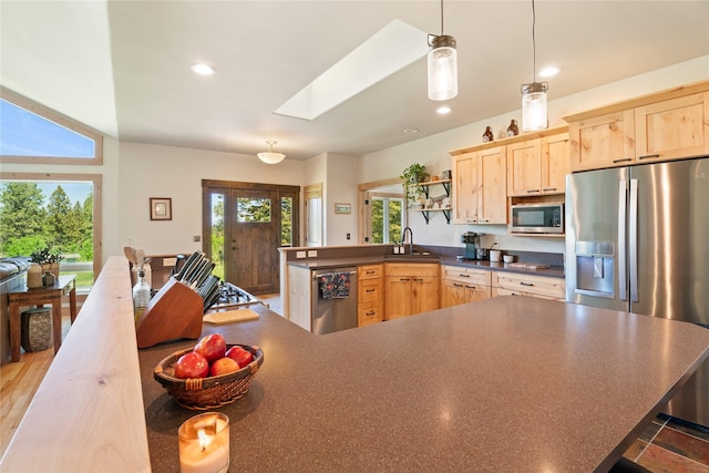 36 Lost Trl, Clancy, MT 59634 - kitchen with appliances with stainless steel finishes, light brown cabinets, a skylight, dark countertops, and a peninsula