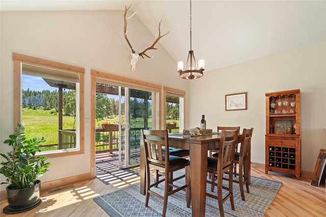 36 Lost Trl, Clancy, MT 59634 - dining room featuring a chandelier, light wood-type flooring, high vaulted ceiling, and baseboards