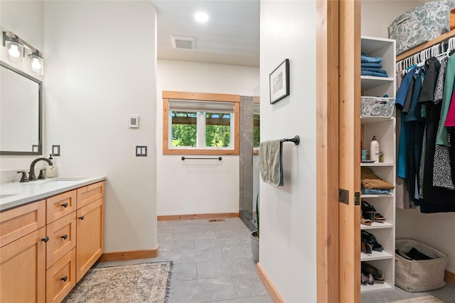 36 Lost Trl, Clancy, MT 59634 - bathroom with double vanity, baseboards, a shower with shower door, a spacious closet, and tile patterned flooring