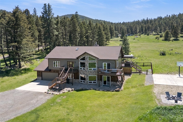 36 Lost Trl, Clancy, MT 59634 - view of front of property featuring stairs, stone siding, a forest view, a wooden deck, and an attached garage