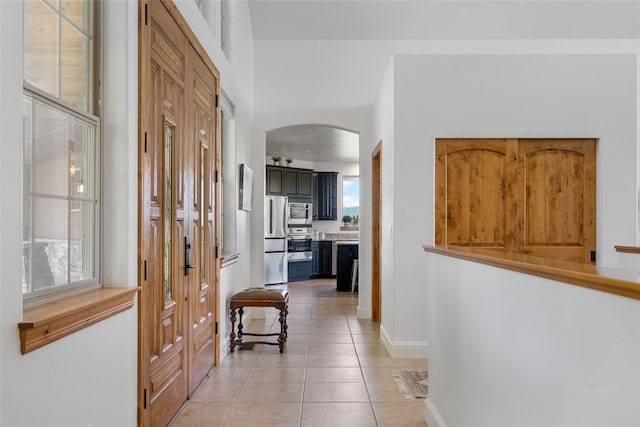 310 Jossie Ln, Kalispell, MT 59901 - hallway featuring arched walkways, light tile patterned floors, and baseboards