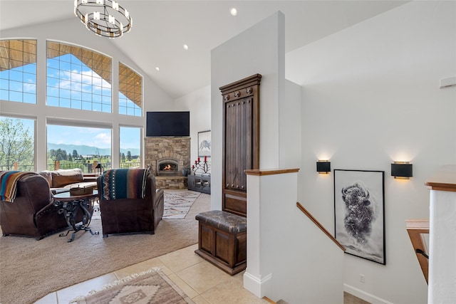 310 Jossie Ln, Kalispell, MT 59901 - living area featuring light tile patterned flooring, high vaulted ceiling, recessed lighting, a stone fireplace, and light carpet