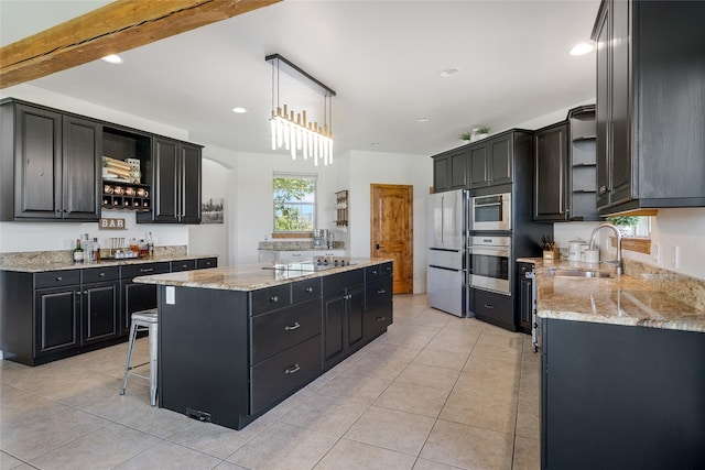 310 Jossie Ln, Kalispell, MT 59901 - kitchen with appliances with stainless steel finishes, open shelves, dark cabinets, a sink, and a kitchen island
